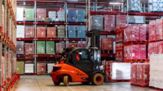 A forklift truck by Linde Material Handling picks up pallets of drinks boxes in the French plant of Coca-Cola European Partners France.