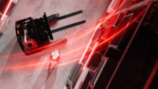 Kırmızı ışık izleriyle kuş bakışı görünen Linde MH reach forklifti Ri16 ve yanında amut yapan kişi.