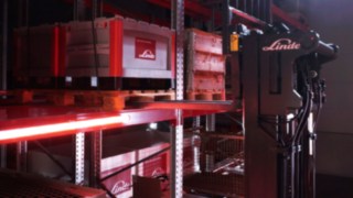 Linde reach forklifti Ri16’nın raf alanında palet taşıması.